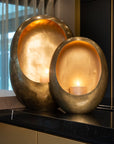 Sfeerbeeld met twee goudkleirige ei vorm kaarsenhouders in verschillend formaat 